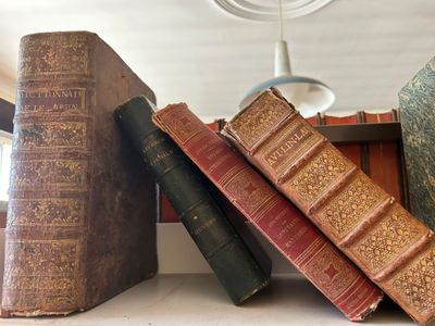 plusieurs vieux livres sont empilés sur une étagère