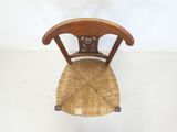 a wooden chair with a wicker seat on a white floor