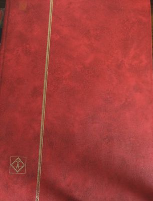 a red book with gold trim sitting on a table