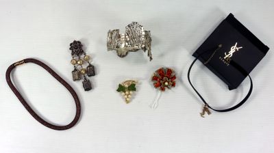 de nombreux bijoux posés sur une table à côté d'un sac noir