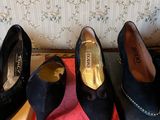 three pairs of black shoes sitting on top of a pink box