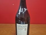 une bouteille de vin posée sur une table, avec un mur rouge en arrière-plan