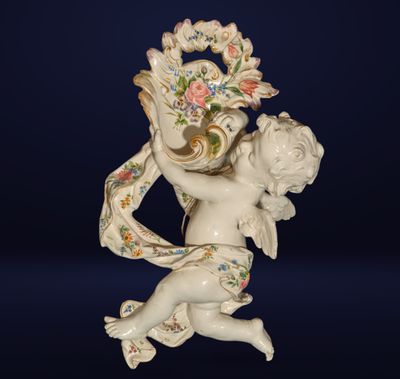 porcelain figurine of a cupid holding a basket of flowers