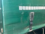 a green semi truck with a flat bed on the back
