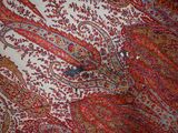 a close up of a red and blue paisley pattern on a white background