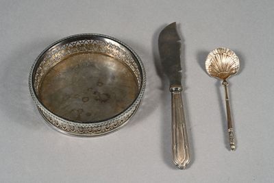 une assiette en argent, avec une cuillère et un couteau à côté