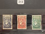 trois timbres de couleurs différentes exposés dans une vitrine