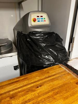 une table en bois sur laquelle est posé un sac en plastique noir