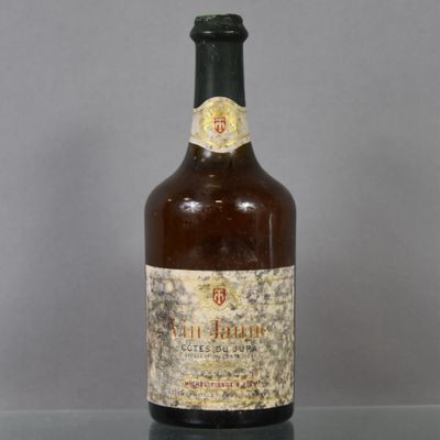 an old bottle of wine sitting on top of a glass table