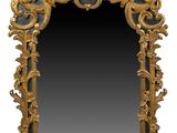 un miroir richement sculpté, doté d'un cadre doré et d'un fond noir