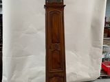 a tall wooden grandfather clock in the middle of a room