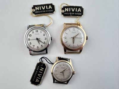 trois montres sont assises l'une à côté de l'autre sur une surface blanche