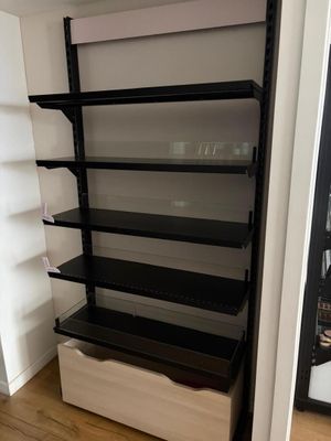 une étagère en noir et blanc avec des tablettes dans une pièce