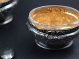 a small silver bowl with a spoon on a table