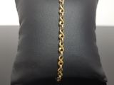 a close up of a gold chain bracelet on a pillow