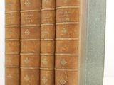 three old books sitting on top of each other on a white surface
