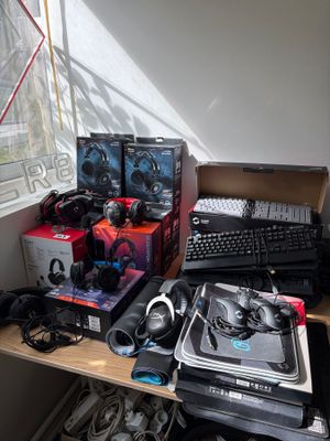 un bureau sur lequel se trouvent un ordinateur portable, un clavier, un casque et d'autres appareils électroniques