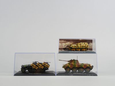 trois modèles différents de véhicules militaires exposés dans une vitrine