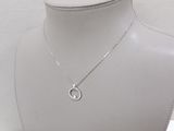 a white mannequin with a silver necklace on top of it