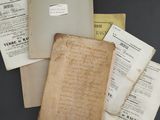 an old book with a lot of papers on top of it