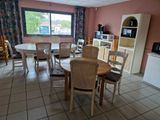 une pièce dans laquelle se trouvent une table, des chaises et une télévision