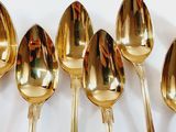 five gold spoons sitting next to each other on a table