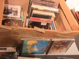 une boîte remplie de CD et des CD posés sur une table
