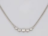 un gros plan sur un collier en argent porté par un mannequin