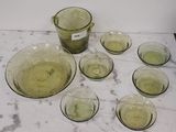 neuf verres et un pichet posés sur une table en marbre