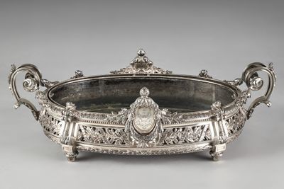 an antique silver plate with ornate carvings and handles on a stand