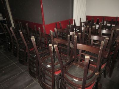 beaucoup de chaises en bois dans une pièce aux murs rouges