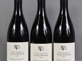 three bottles of wine are lined up on a table