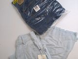 deux paires de jeans bleus posées sur une table blanche