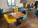 brightly colored chairs and tables in a restaurant with a fireplace in the background
