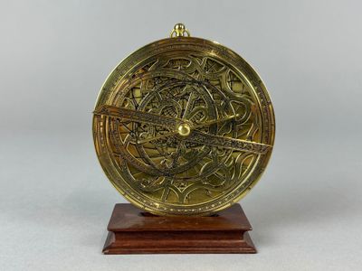 un gros plan d'une horloge en laiton posée sur un socle en bois