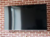 un téléviseur à écran plat fixé à un mur de briques