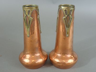 deux vases en cuivre posés l'un à côté de l'autre sur une table