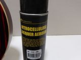 a can of aerosol next to a guitar on a table