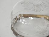 a glass bowl with a gold handle on a white table