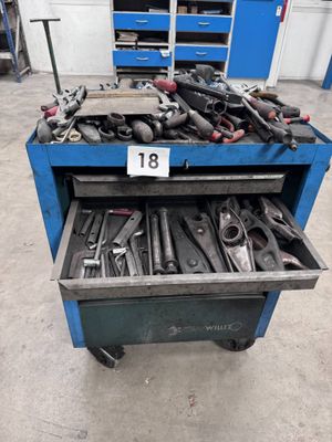 de nombreux outils dans une boîte à outils bleue, dans un garage