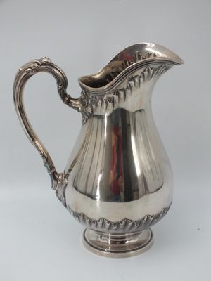 a silver pitcher that is sitting on a table