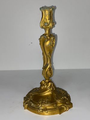 bougeoir doré surmonté d'une bougie en verre vert