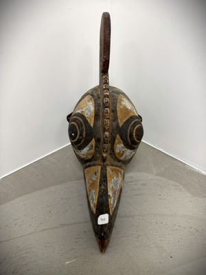 a wooden mask on the floor in a room