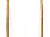 an empty gold frame on a white wall with a white background
