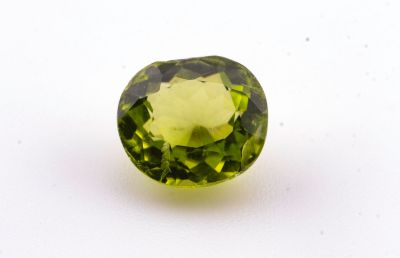 un gros plan d'une pierre précieuse verte sur une surface blanche