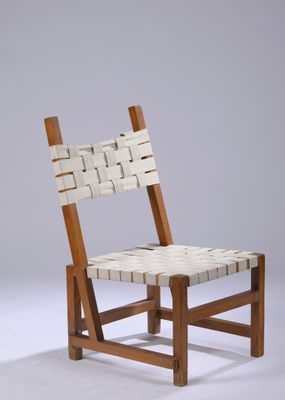 La chaise est en bois et possède une assise tressée.