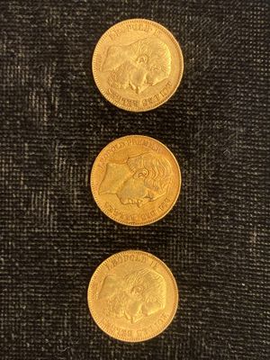 trois pièces d'or empilées les unes sur les autres sur un tissu noir