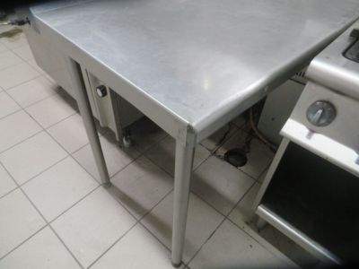 a stainless steel table in the middle of a kitchen