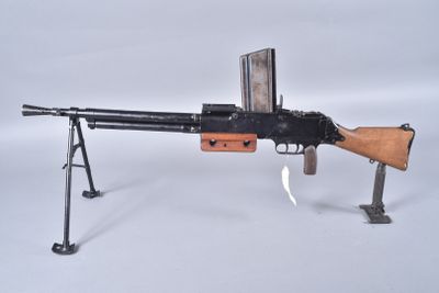 an old machine gun on a stand on a white surface