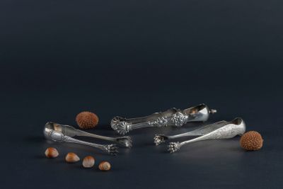 four silver spoons and two silver spoons on a black surface